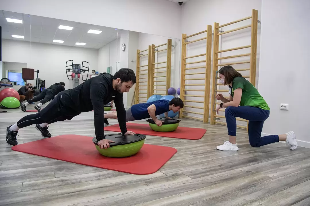 A rehabilitation therapist conducts exercise therapy classes with patients suffering from lower back pain